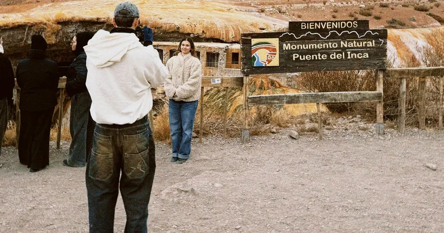 Visitors in front of the Puente del Inca natural monument and its entrance sign