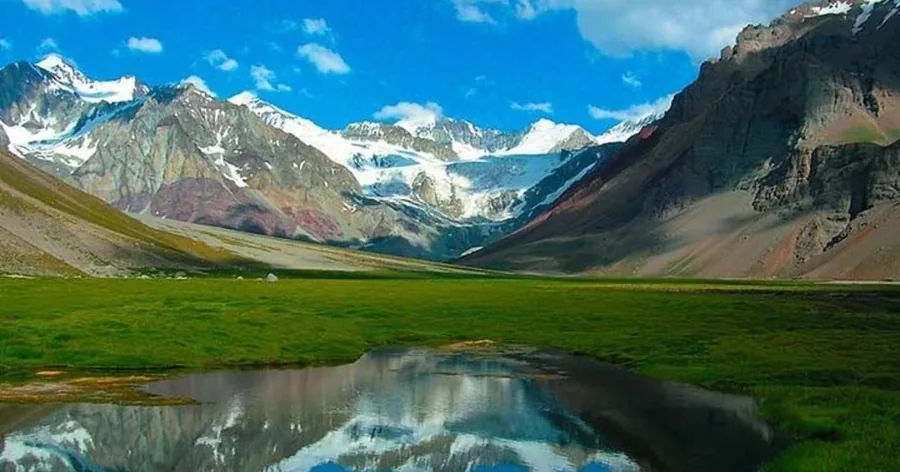 The snowy south face of Aconcagua reflected in the green Laguna de Horcones on a clear day